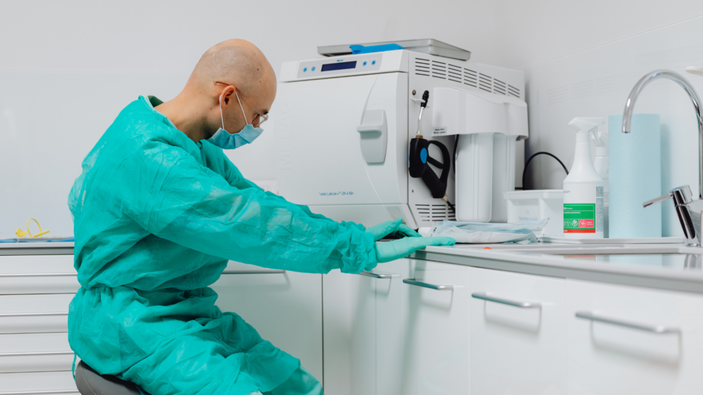 Orthodontic sterilization and records technician managing infection control equipment.